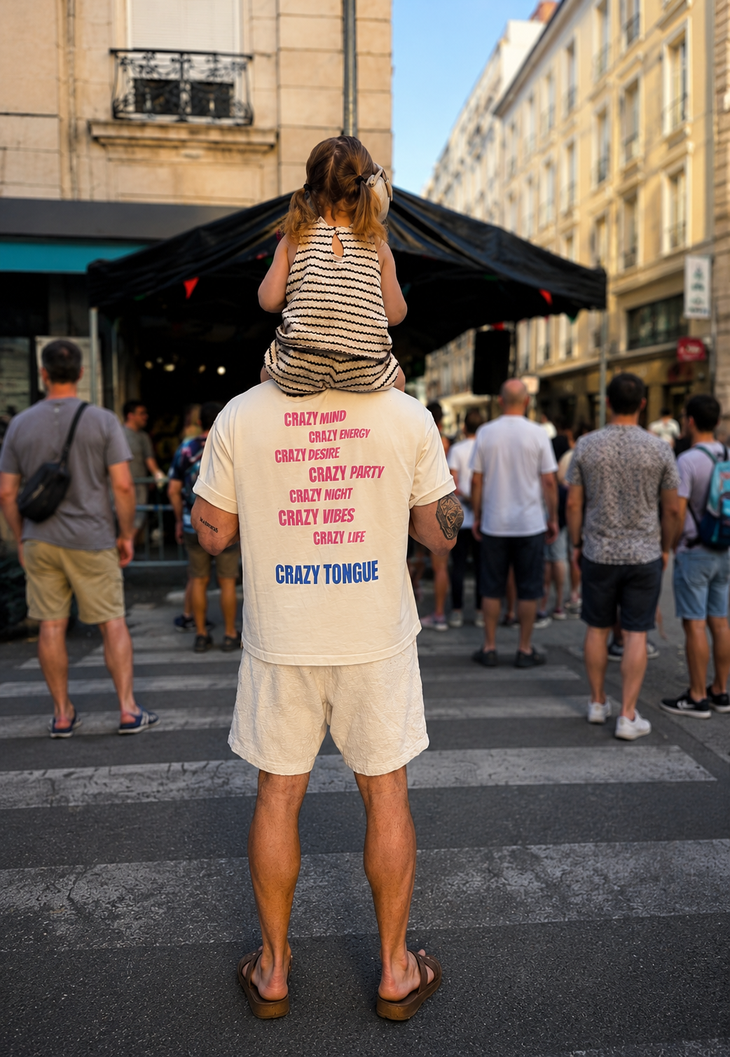 Le fondateur de Crazy Tongue avec sa fille sur les épaules dans une rue de Lyon