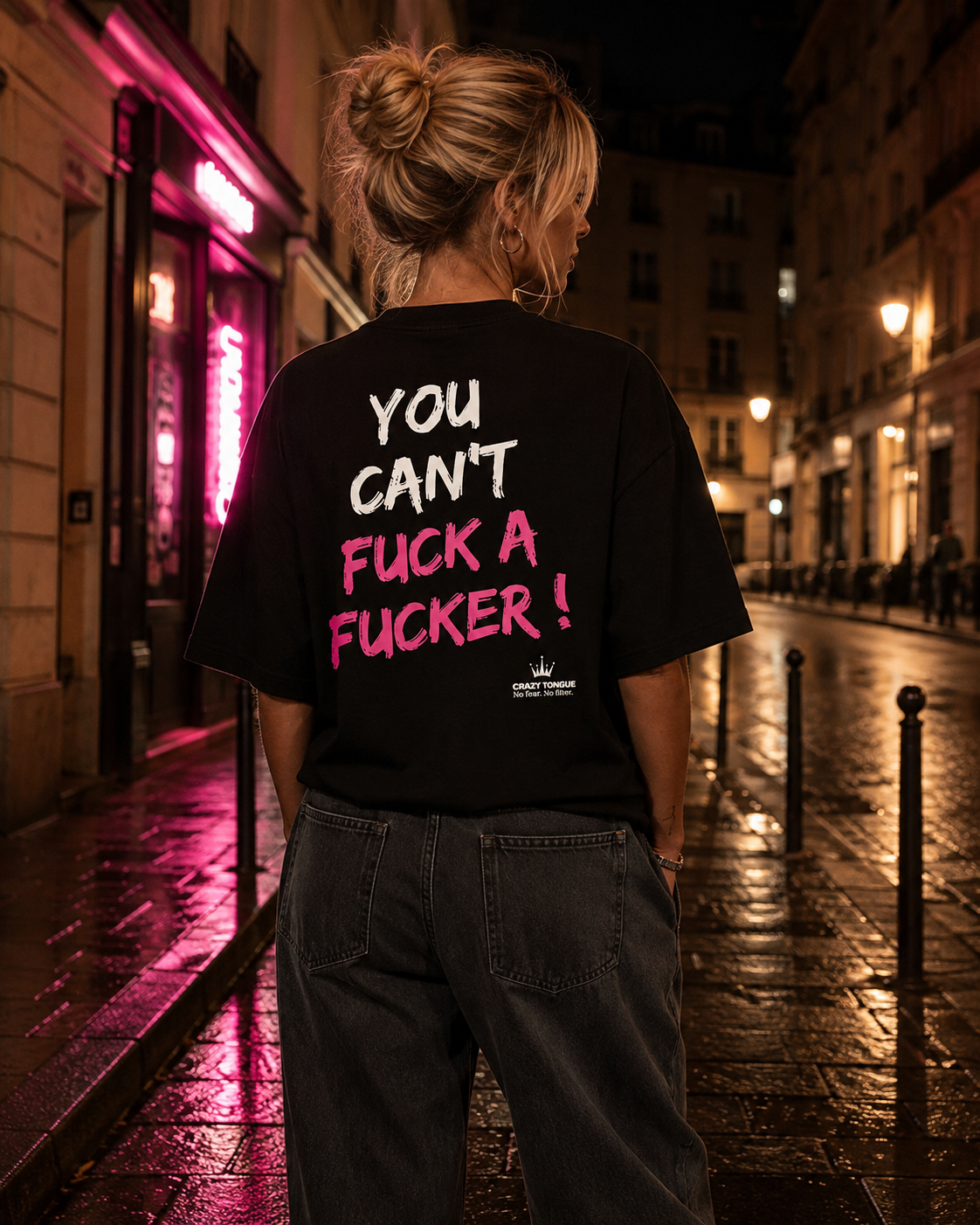 Femme portant le t-shirt noir Crazy Tongue HARD TO HANDLE de dos, artwork rose, dans une rue de nuit.